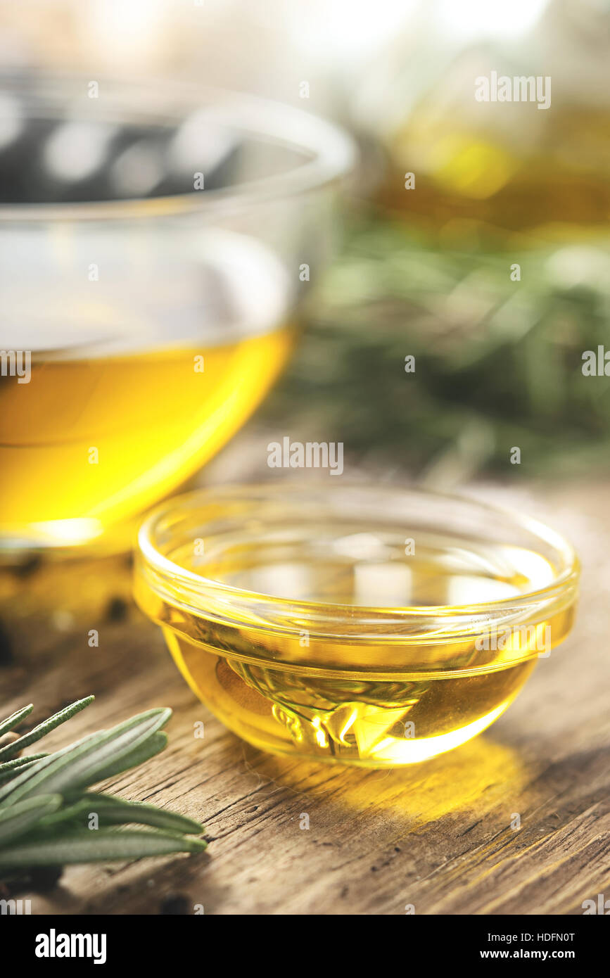 Olivenöl in der Glasschüssel auf Holztisch vertikale Stockfoto