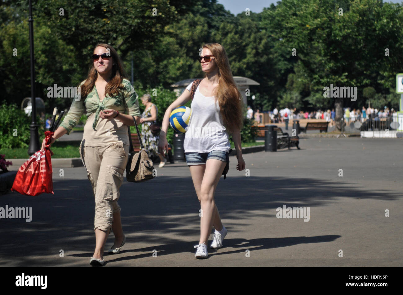 Russische Mädchen, die im Gorki Park spazieren, mit einem Geldbeutel und einem Volleyball. Moskau, Russland Stockfoto