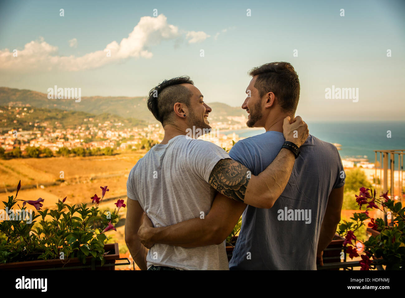 Rückansicht des homosexuelles Paar umarmt Nd sahen einander auf Grund des Resorts. Stockfoto