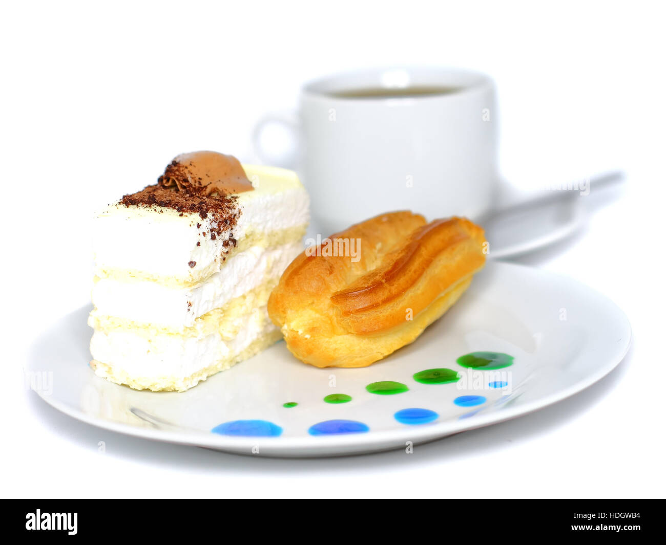 Biskuitkuchen und Eclair Kuchen auf Teller mit Obst Saft Flecken. Isoliert Stockfoto