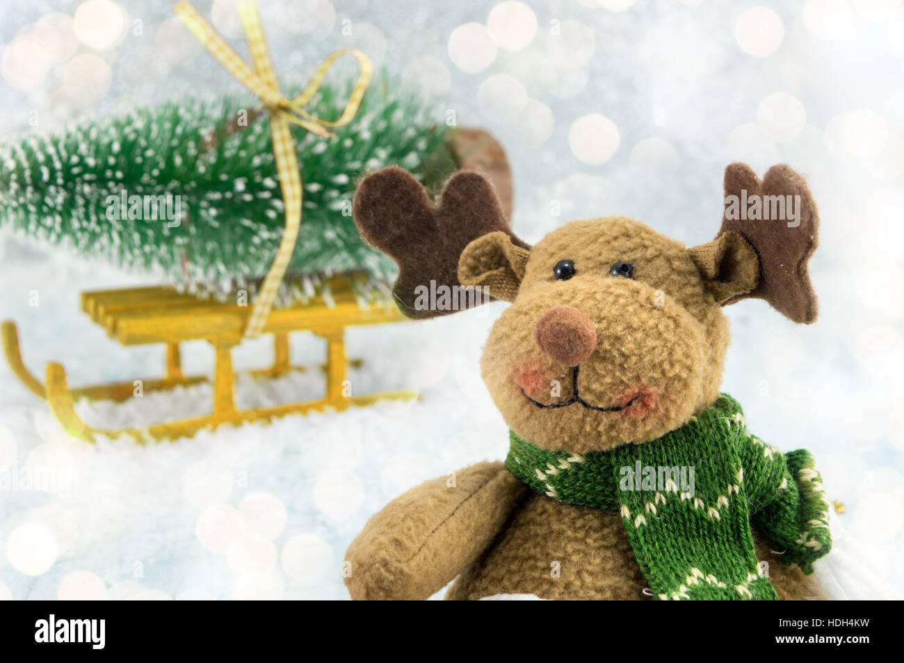 Spielzeug-Rentier und einen Weihnachtsbaum auf dem Schlitten mit Schnee bedeckt Stockfoto