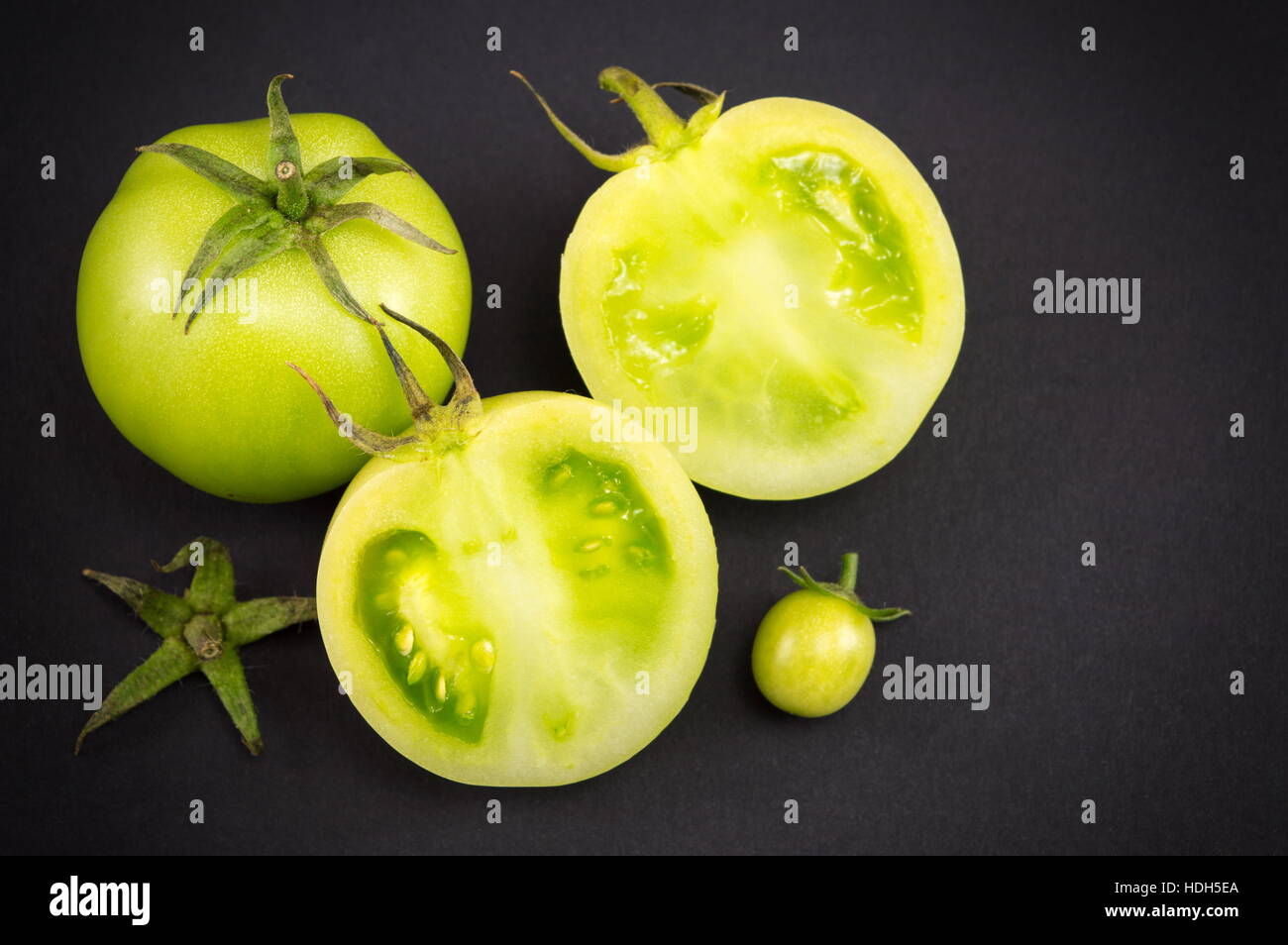 In Scheiben geschnittenen rohe grünen Tomaten auf dunklen backgeround Stockfoto