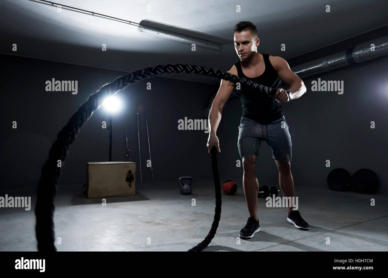 Sportlicher Mann Anstrengung auf Crossfit Training mit Seilen Stockfoto