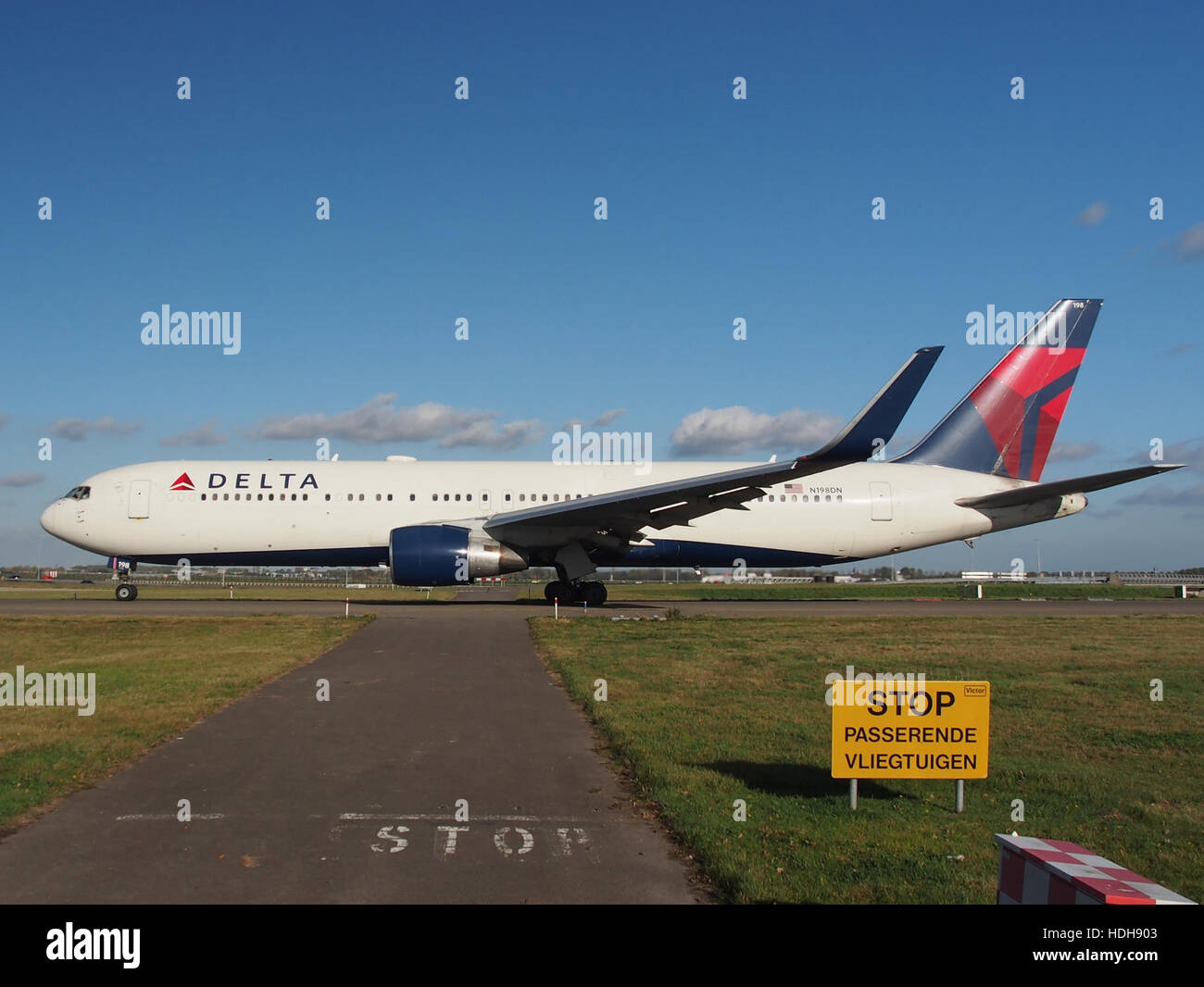 N198DN, ein Verkehrsflugzeug, fährt am Flughafen Schiphol in Amsterdam auf die Start- und Landebahn 36L. Dieses Flugzeug bereitet sich auf den Start vor und bietet eine freie Sicht auf den Rumpfbereich und die geschäftige Flughafenumgebung. Schiphol ist einer der verkehrsreichsten internationalen Flughäfen Europas und bietet täglich zahlreiche Flüge an. Stockfoto