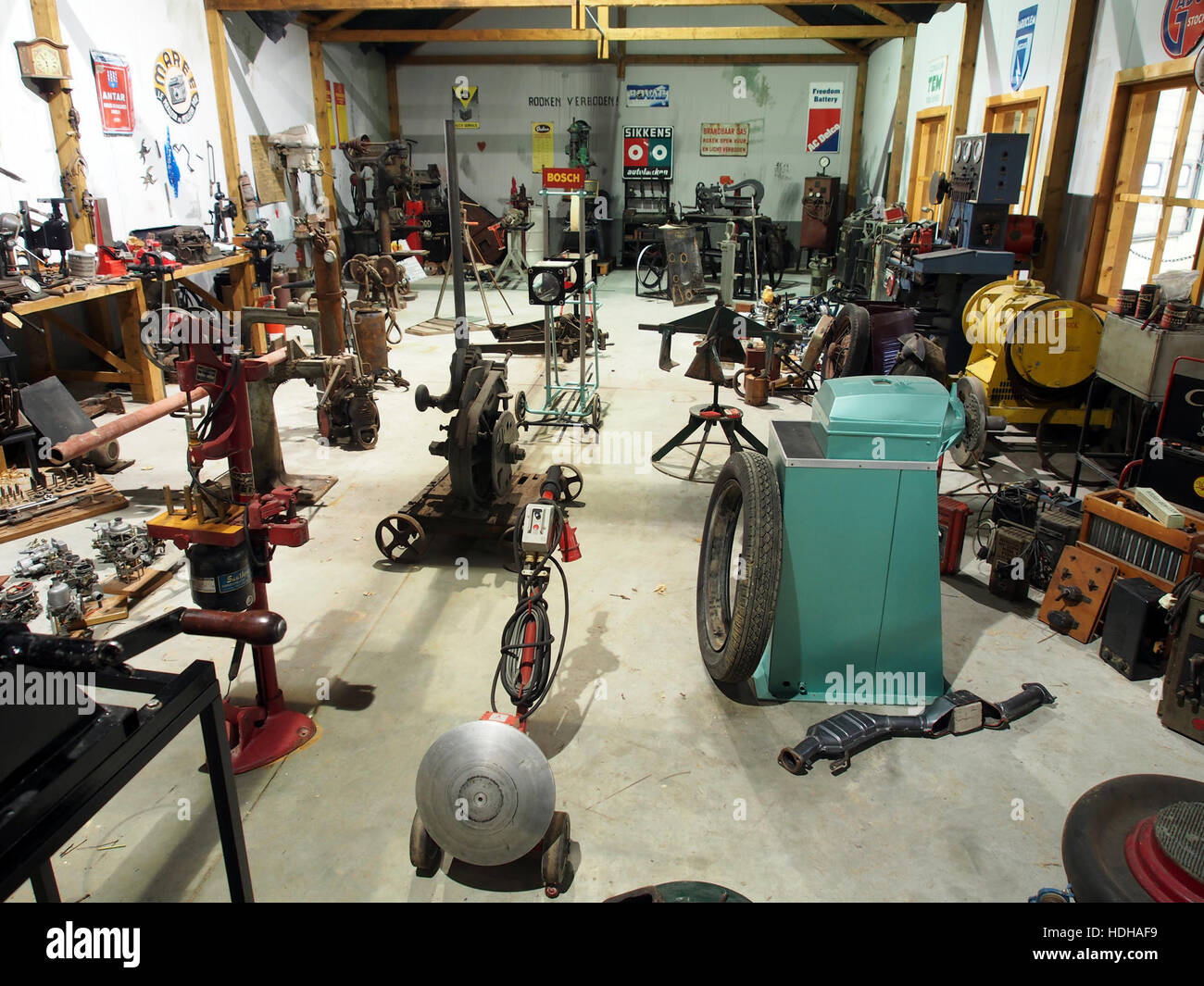 Ein historisches Foto aus einer Ford-Werkstatt, das Arbeiter zeigt, die Ford-Fahrzeuge montieren. Dieses Bild zeigt die industriellen Prozesse und die Arbeitskräfte hinter den frühen Produktionstechniken von Ford und unterstreicht den Umfang und die Effizienz der Automobilherstellung während des frühen 20. Jahrhunderts. Stockfoto