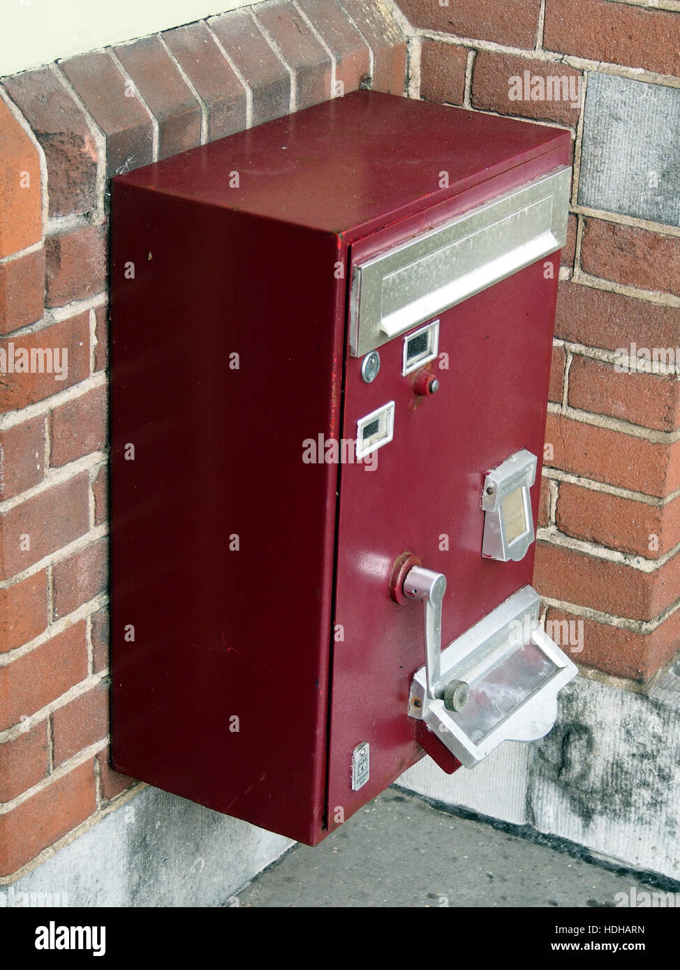 Das Bild zeigt einen alten Briefmarkenautomat, wahrscheinlich aus der Mitte des 20. Jahrhunderts, der eine vergangene Epoche der Postdienste und -Technik darstellt. Stockfoto