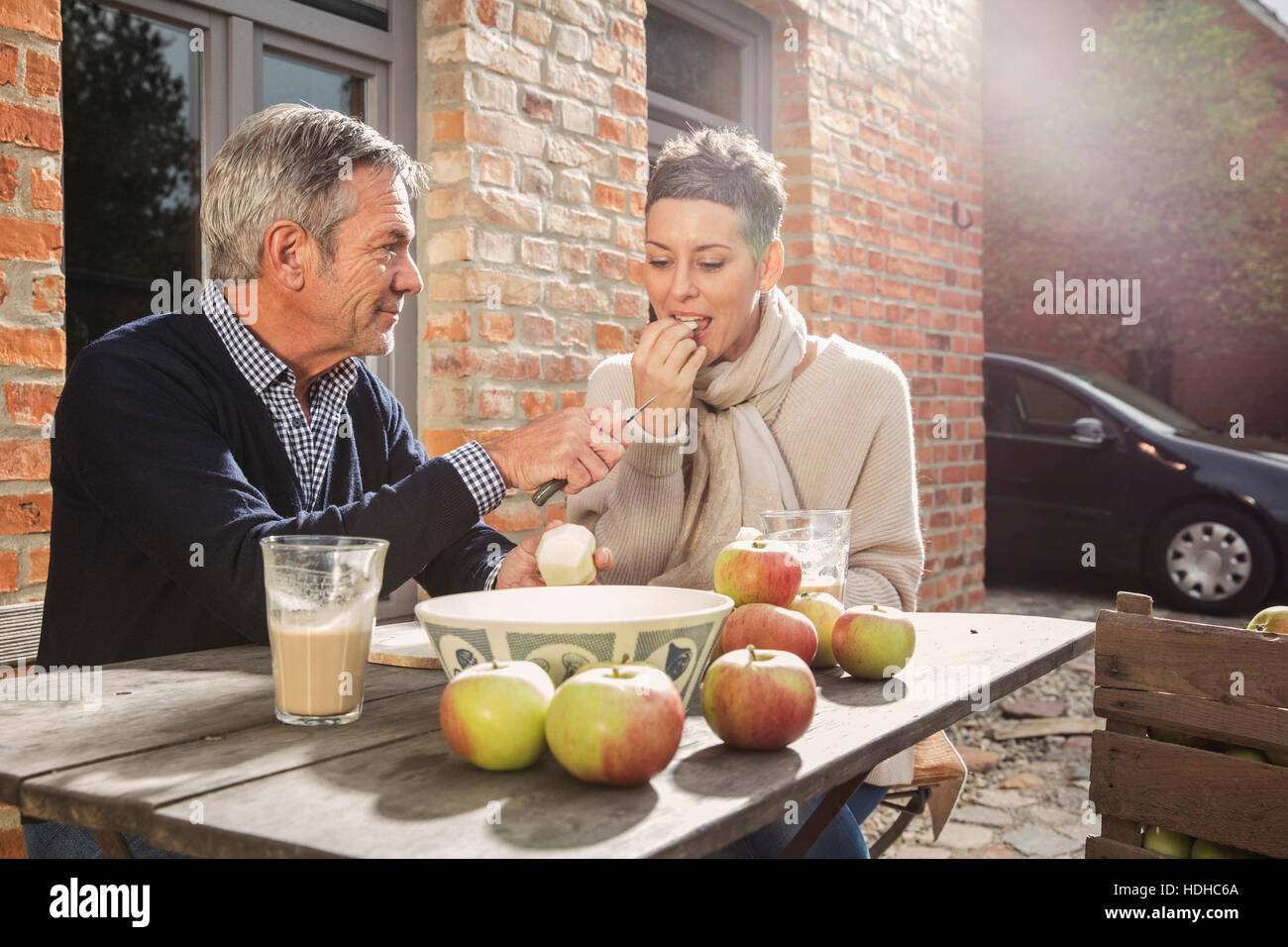 Älteres paar Verzehr von Äpfeln im Hinterhof Stockfoto