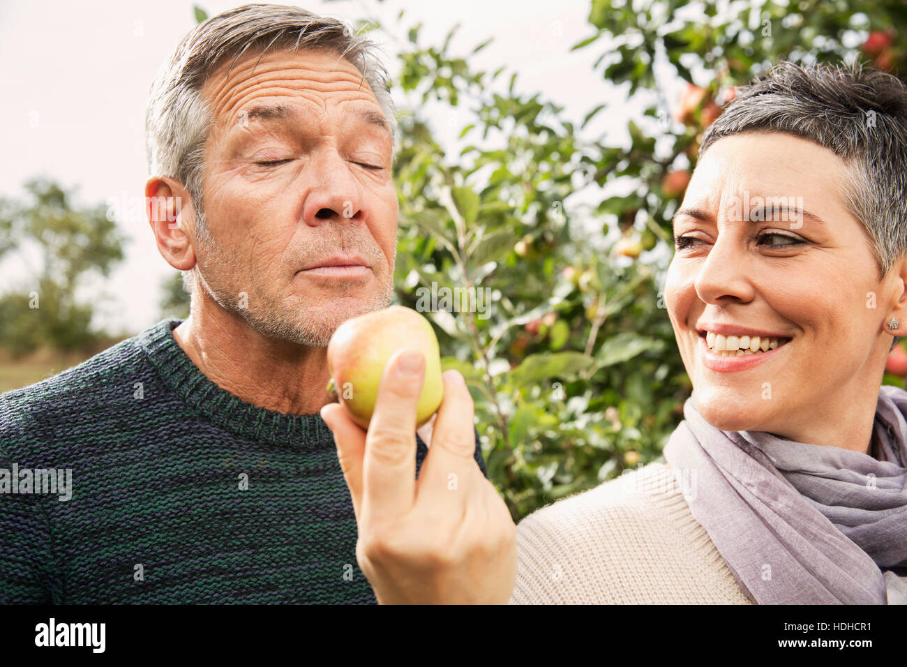 Frau hielt Apple für Mann im Obstgarten Stockfoto