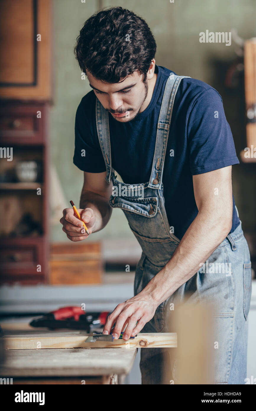 Tischler markieren auf Holz mit Bleistift und Lineal am workshop Stockfoto