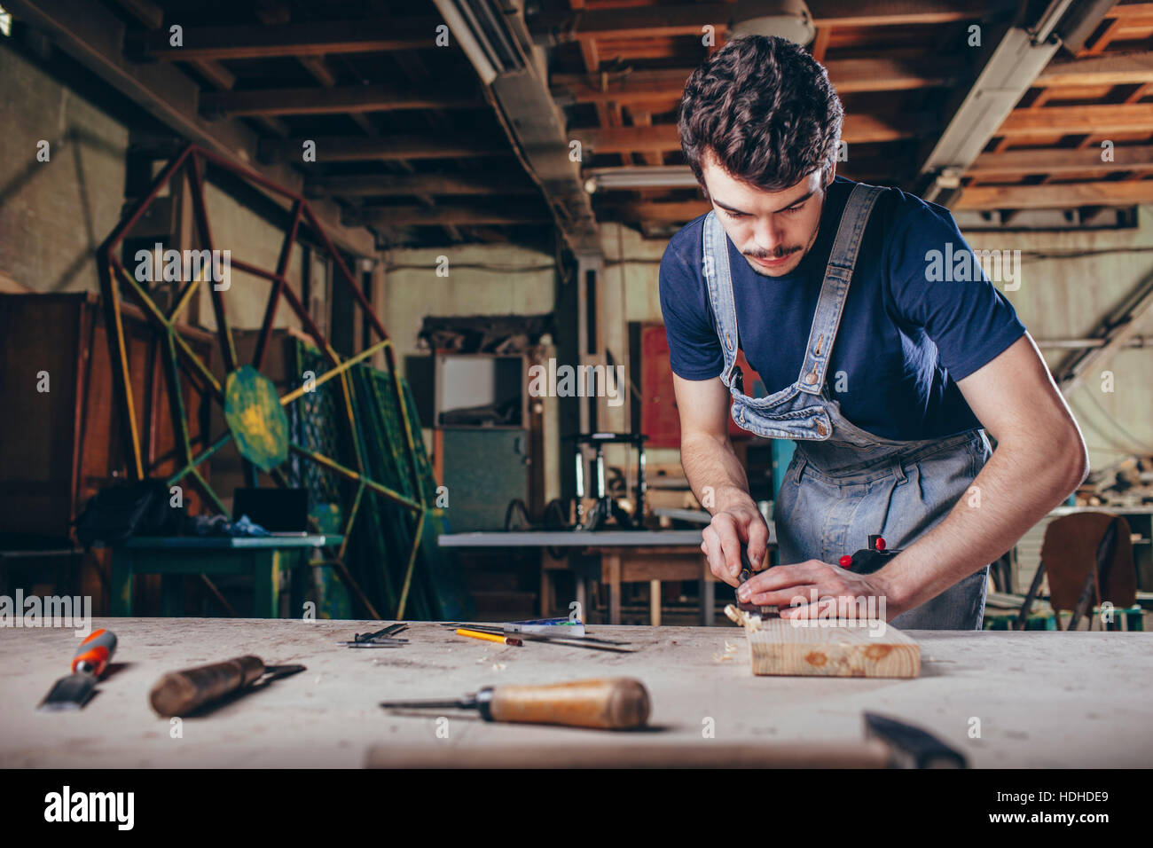 Tischler mit Meißel auf Holzbrett in Werkstatt Stockfoto