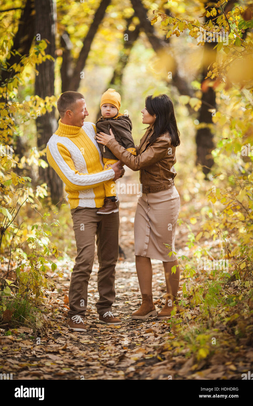 Gesamte Länge der Eltern betrachten Baby junge im Park im Herbst Stockfoto