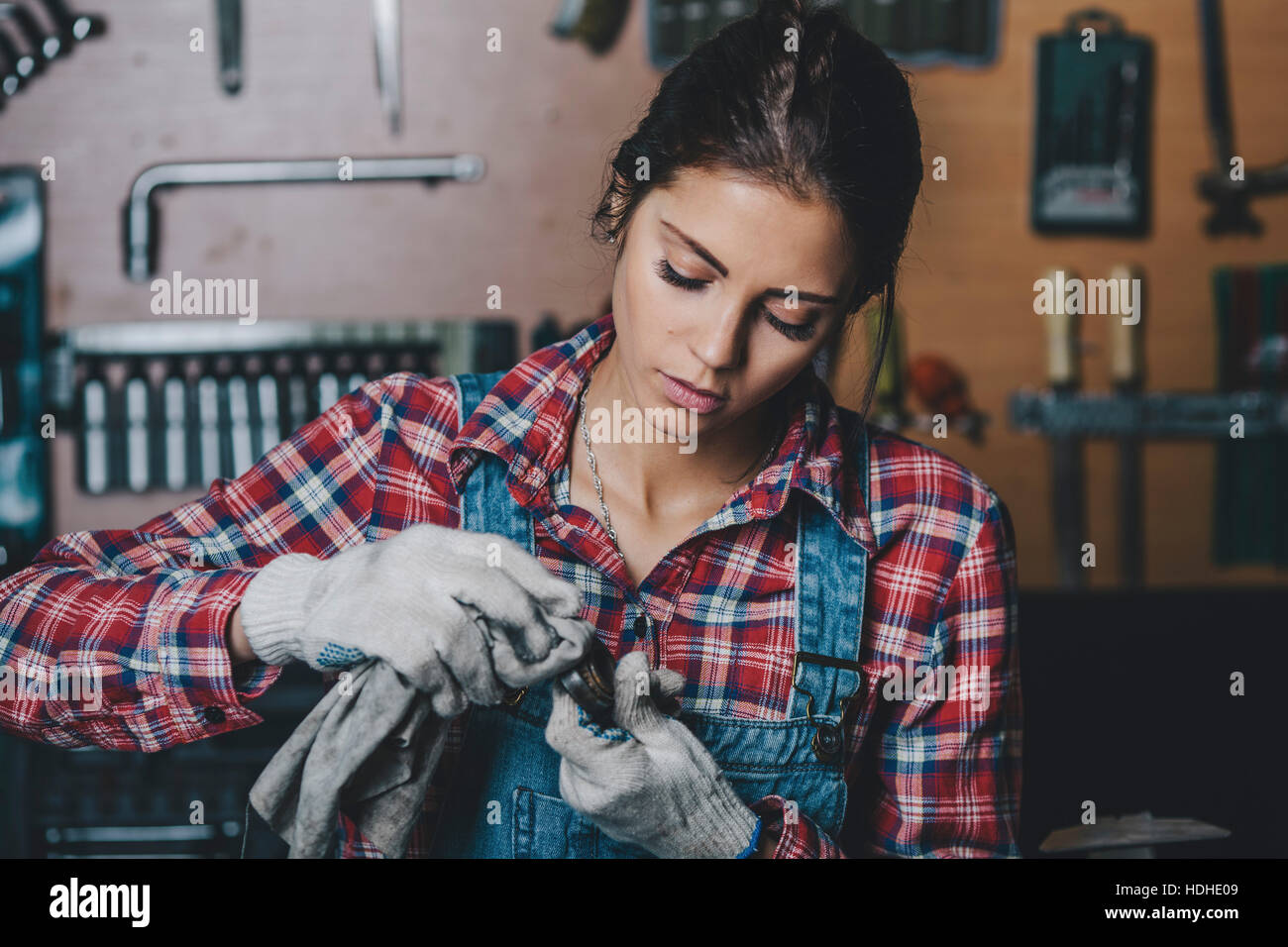Weibliche Mechaniker Reinigung Fahrzeugteil am workshop Stockfoto