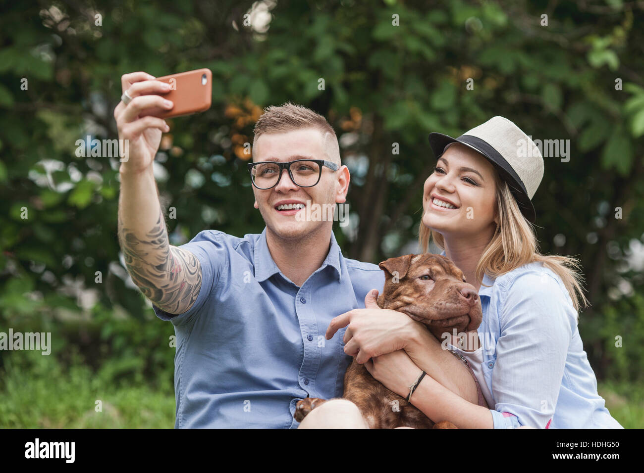 Ein paar mit ihren Shar-pei/Staffordshire Terrier Hund im Park unter einem selfie Stockfoto