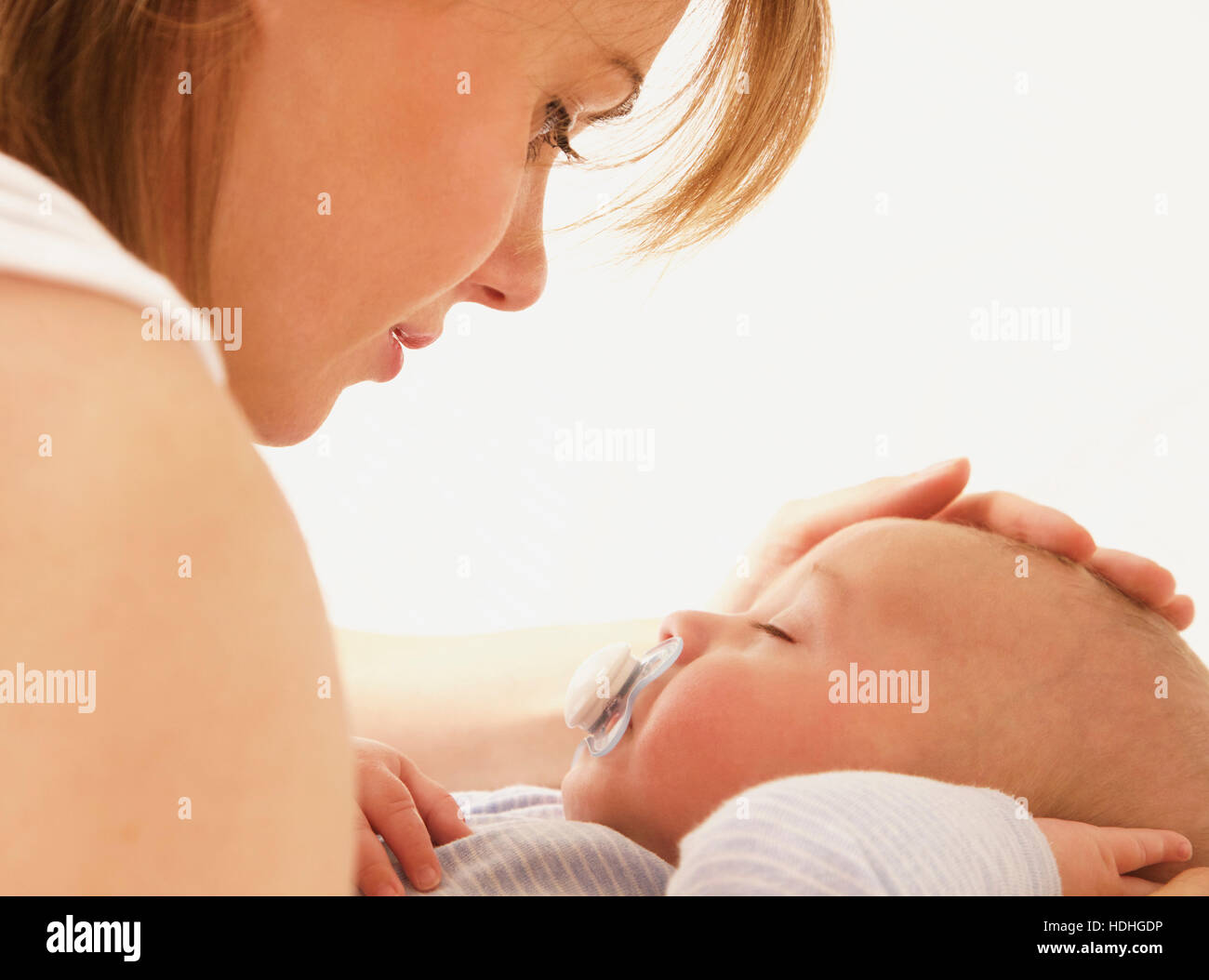 Liebevolle Mutter betrachten Babyjungen schlafen auf Bett Stockfoto