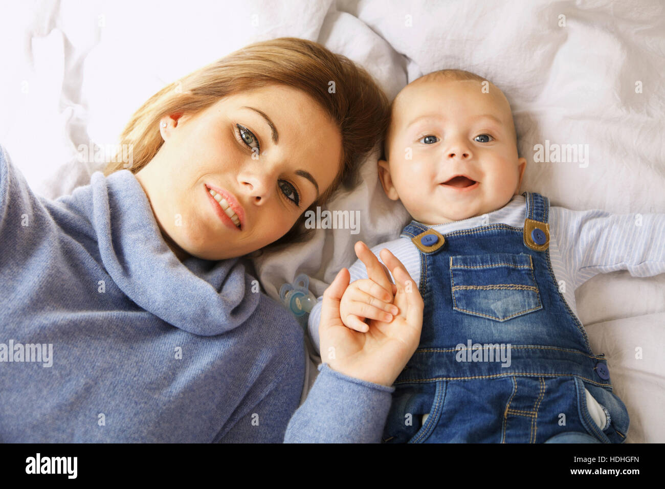 Direkt oben geschossen der glückliche Mutter liegend mit niedlichen baby Boy am Bett Stockfoto