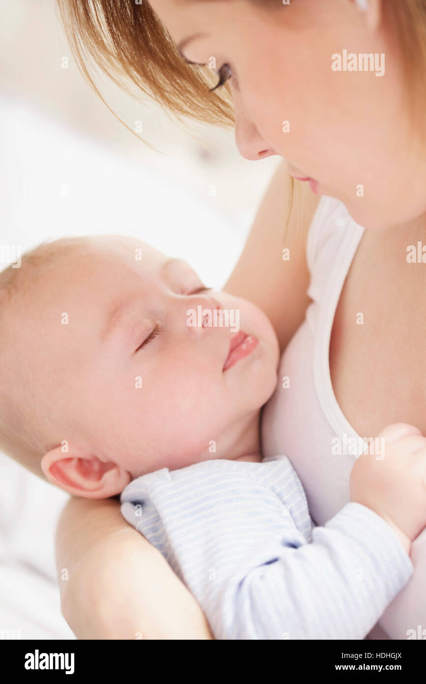 Nahaufnahme des tragenden Baby junge Mutter zu Hause Stockfoto