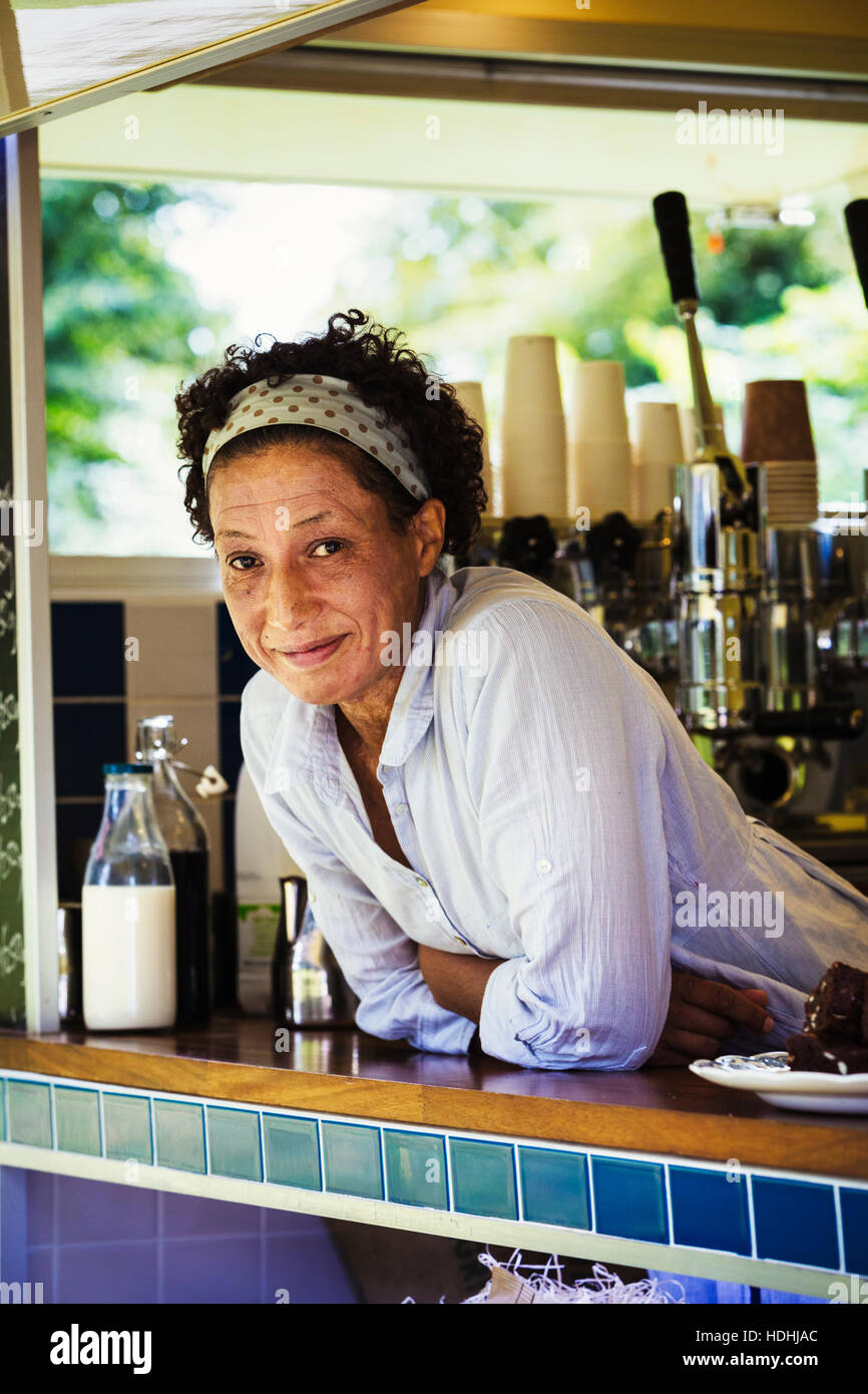 Die Frau beugte sich über den Zähler von einem mobilen Coffee-Shop. Stockfoto