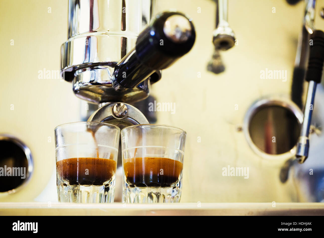 Nahaufnahme von Espresso-Maschine und zwei Gläser Espresso. Stockfoto