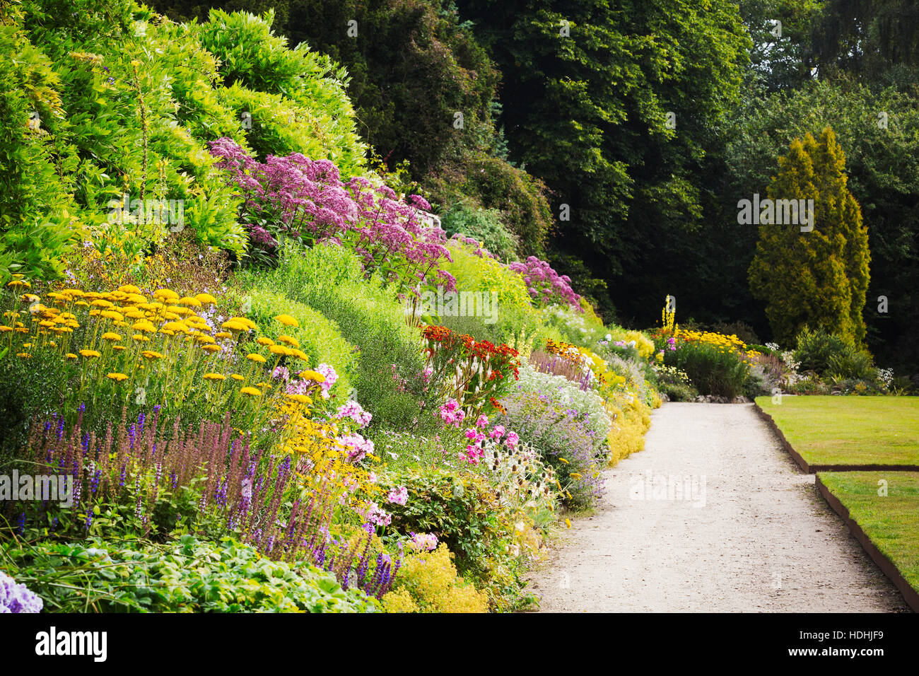 Wanderweg entlang einer gemischten Beet Blumen am Waterperry Gärten in Oxfordshire. Stockfoto