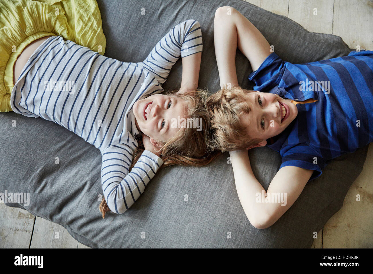 Eine Familie zu Hause.  Ein Junge und ein Mädchen mit dem Kopf auf dem Sofa liegen nahe beieinander. Ansicht von oben. Stockfoto