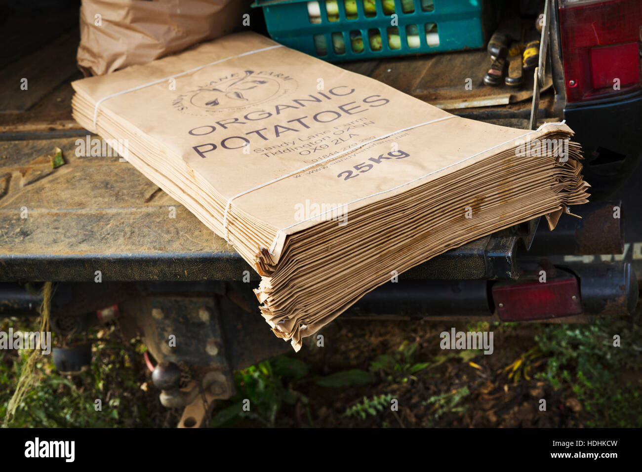 Ein Haufen von bedrucktem Papier Gemüse Säcke auf einem Bauernhof Wagen beschriftet Bio-Kartoffeln. Kleinbetrieb-kleine Agribusiness-Food-Kultur Stockfoto