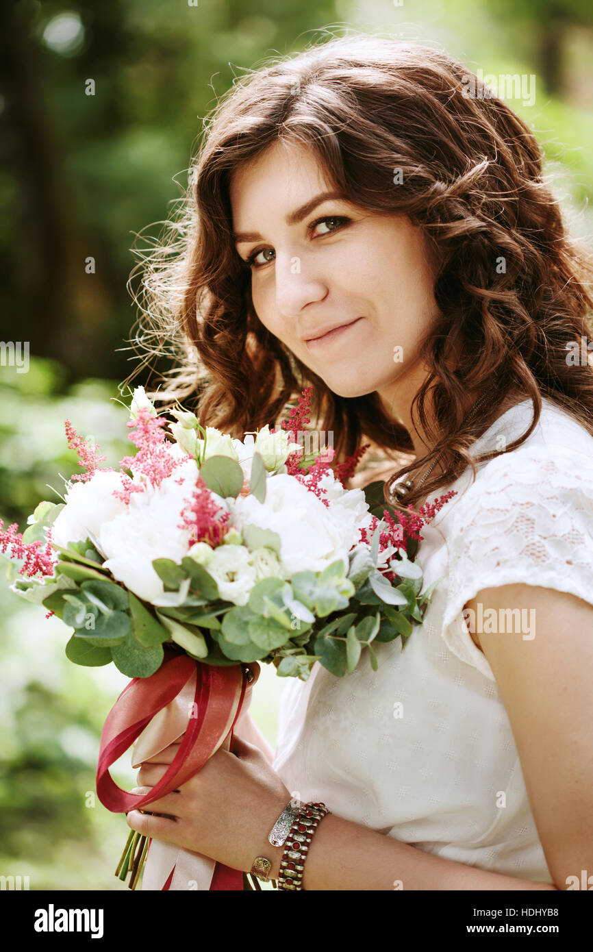 Lächelnde Braut mit Hochzeit Blumen Nahaufnahme Stockfoto