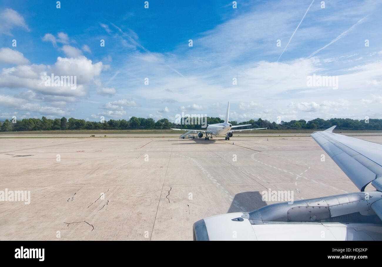 Flughafen-Asphalt mit Motor, Flügel und Flugzeug an einem sonnigen Tag. Stockfoto