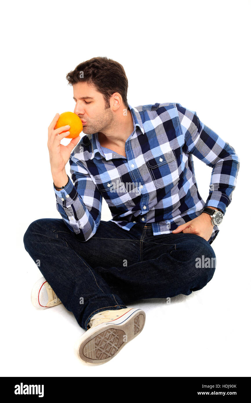 Porträt des Mannes riechen eine Orange sitzen Stockfoto