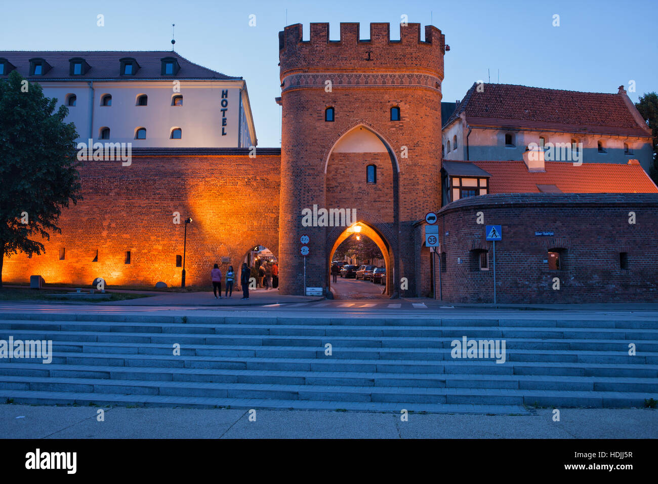 Tor (Brama Mostowa) und Stadtmauer in der Abenddämmerung in Torun, Polen, alte mittelalterliche Stadtbefestigung zu überbrücken Stockfoto