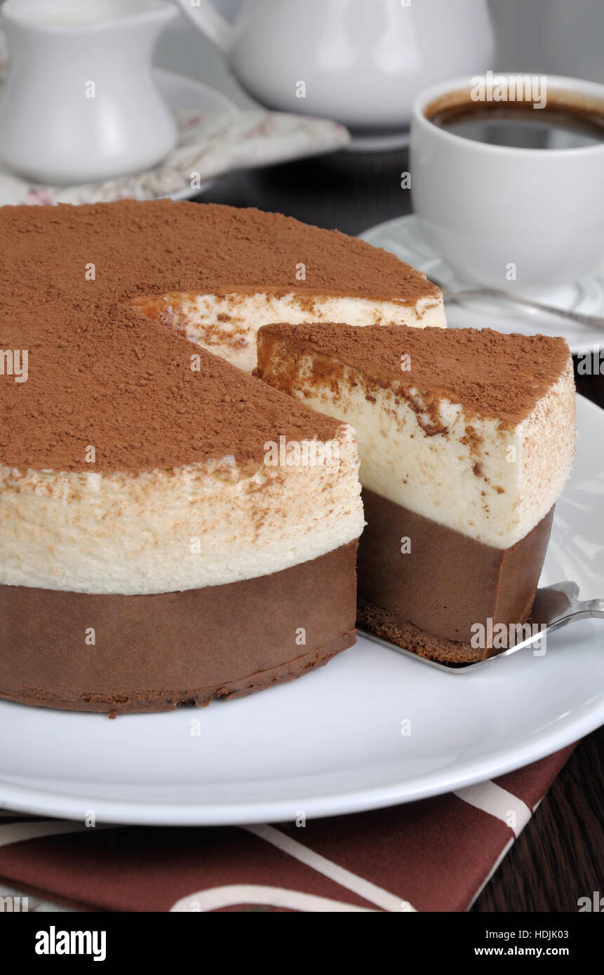 Schneiden Sie ein Stück Schokolade mit Vanille-Mousse Kuchen bedeckt Kakao Stockfoto