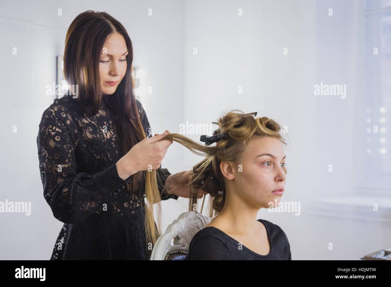 Professioneller Friseur Frisur zu tun, denn junge Frau mit langen Haaren hübsche Stockfoto