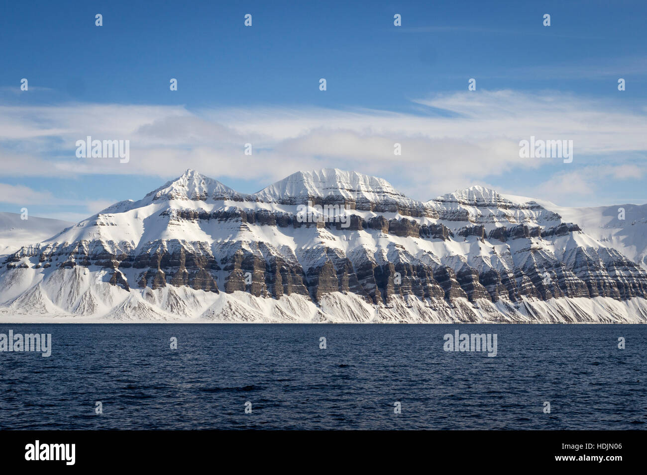 Kleine Kette der Berge entlang der Küste Fjord im nördlichsten Insel Spitzbergen, Norwegen. Sieht aus wie ein Dessert-Kuchen. Stockfoto