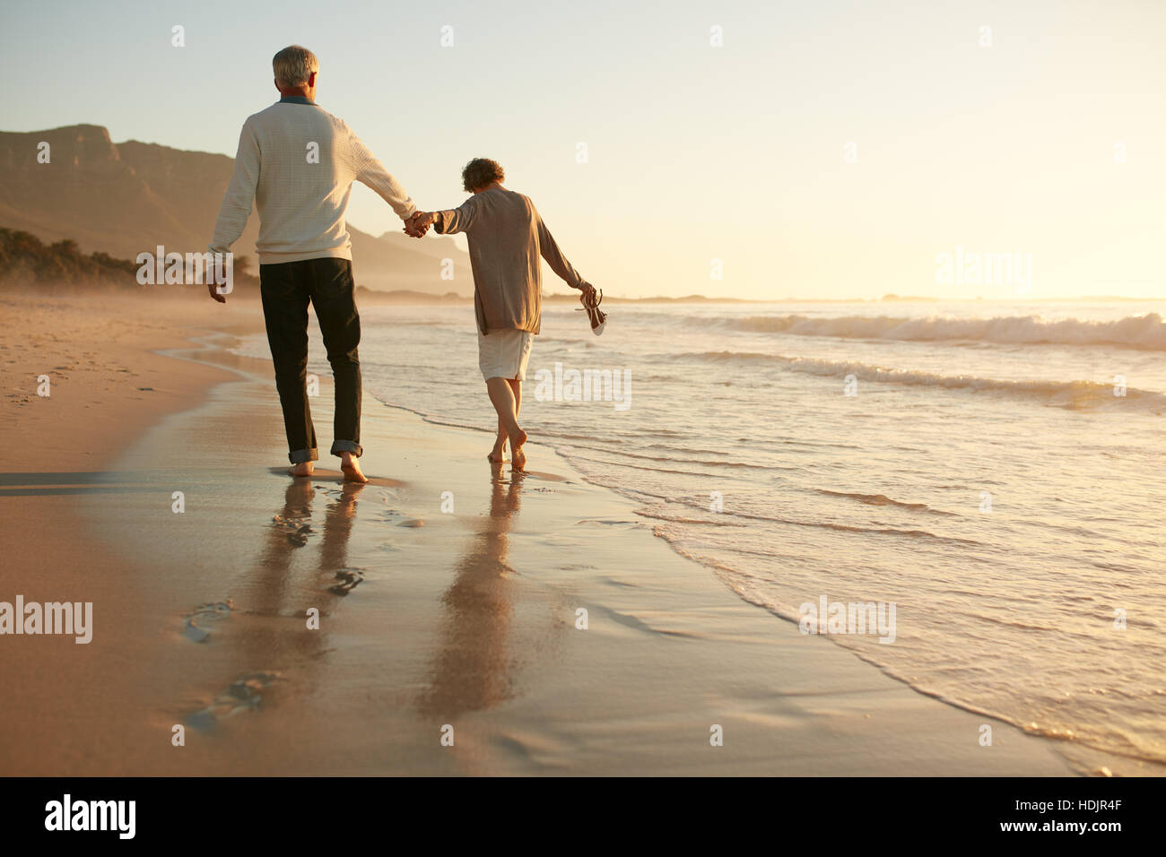 Voller Länge Rückansicht Schuss älteres Paar, die Spaß am Strand. Älteres Paar gemeinsam Urlaub im Sea Shore. Stockfoto