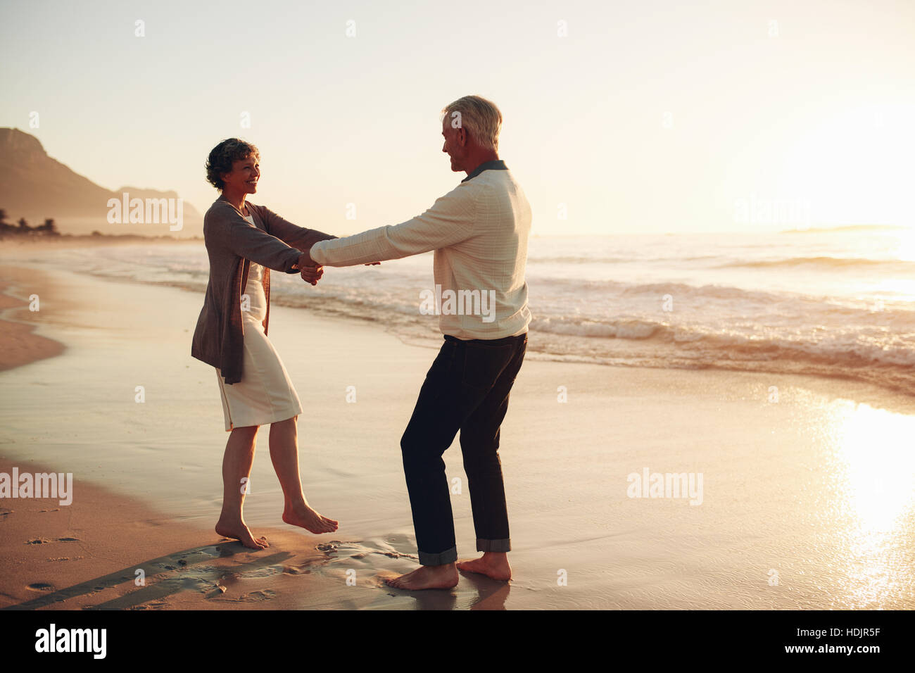 Voller Länge Schuss von romantischen älteres paar Hand in Hand und genießen einen Tag am Strand. Älteres Paar am Strand amüsieren. Stockfoto