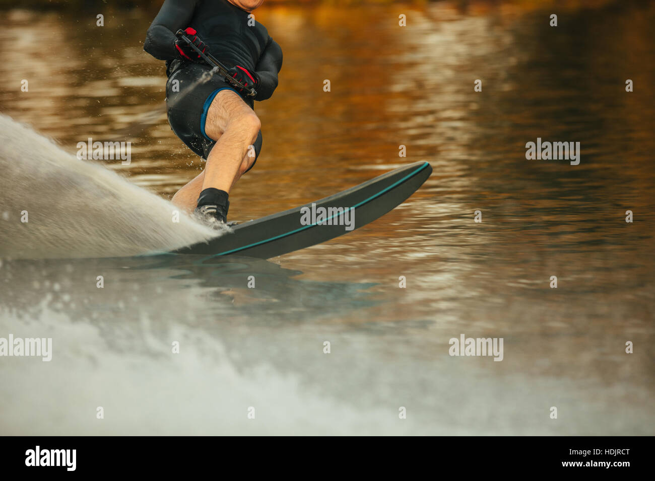 Mann reitet Wakeboard an einem See. Männliche Wasserski und Surfen über den See. Stockfoto