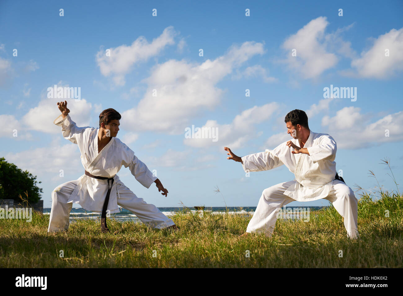 Kampf- und extreme Sportarten. Hispanische Männer trainieren im Karate und  traditionelle Kampfkunst. Simulation der Kampf am Strand nahe dem Meer  Stockfotografie - Alamy