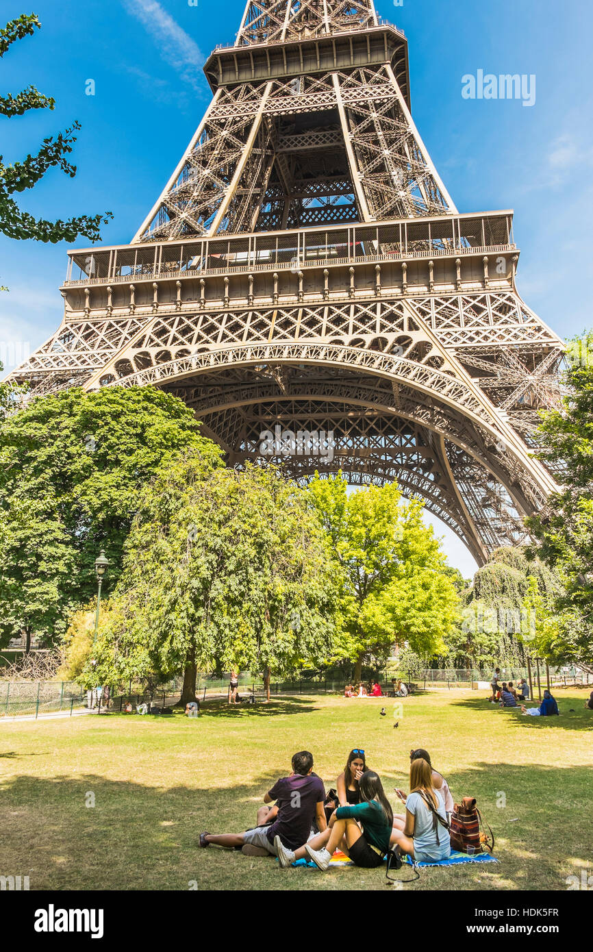 Gruppe von Jugendlichen mit einem Picknick unter dem Eiffelturm Stockfoto
