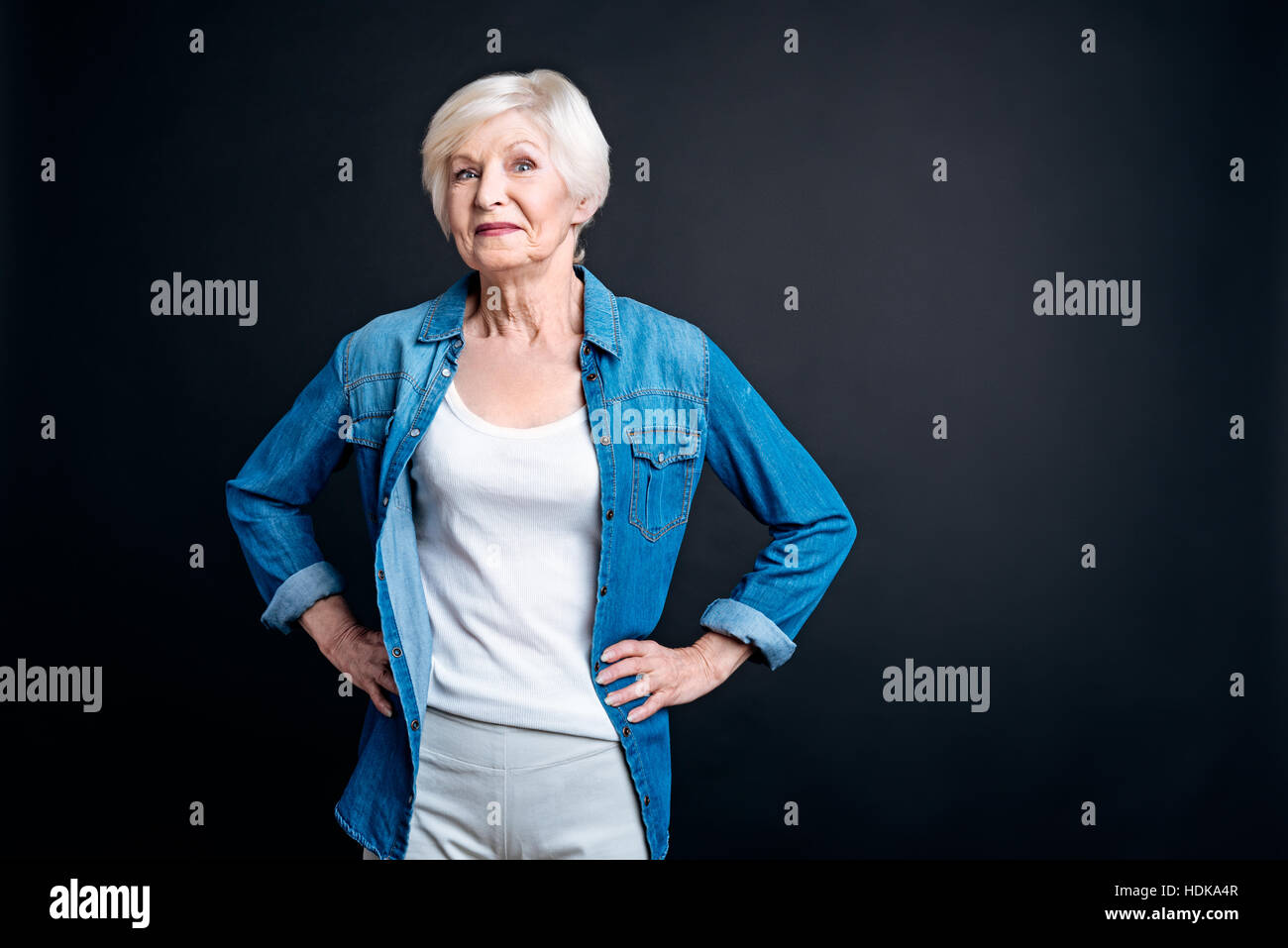 Begeistert Eldely Frau auf schwarzem Hintergrund Stockfoto