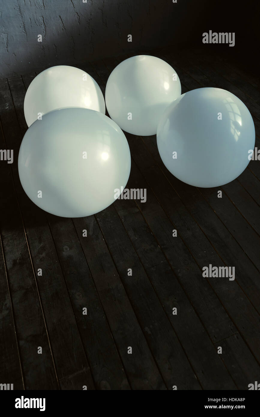 Mehrere große Luftballons liegen im dunklen beleuchteten studio Stockfoto