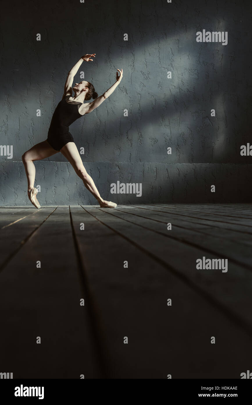 Charismatische junge Balletttänzerin, die Ausbildung in der schwarzen farbigen Raum Stockfoto