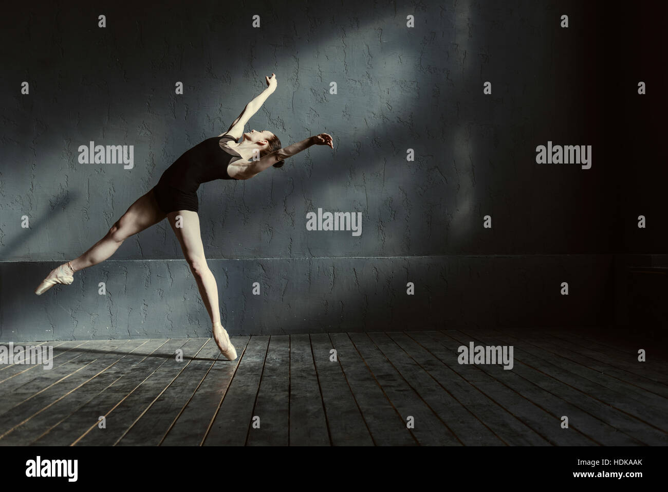 Geschickte junge Balletttänzerin in die schwarzen farbigen Raum handeln Stockfoto
