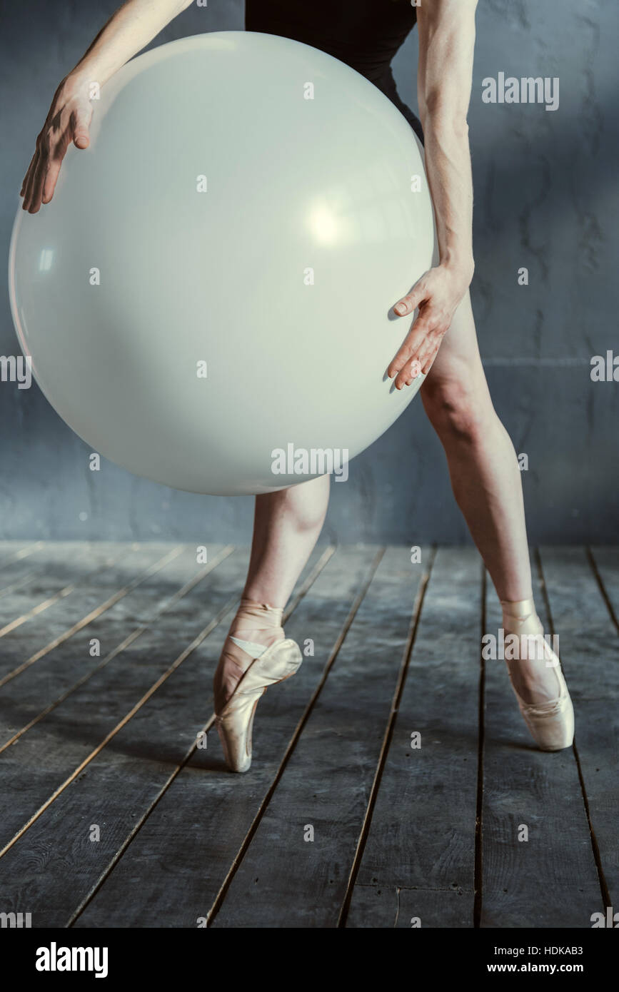 Schlanke Tänzerin hält den großen Ballon im studio Stockfoto