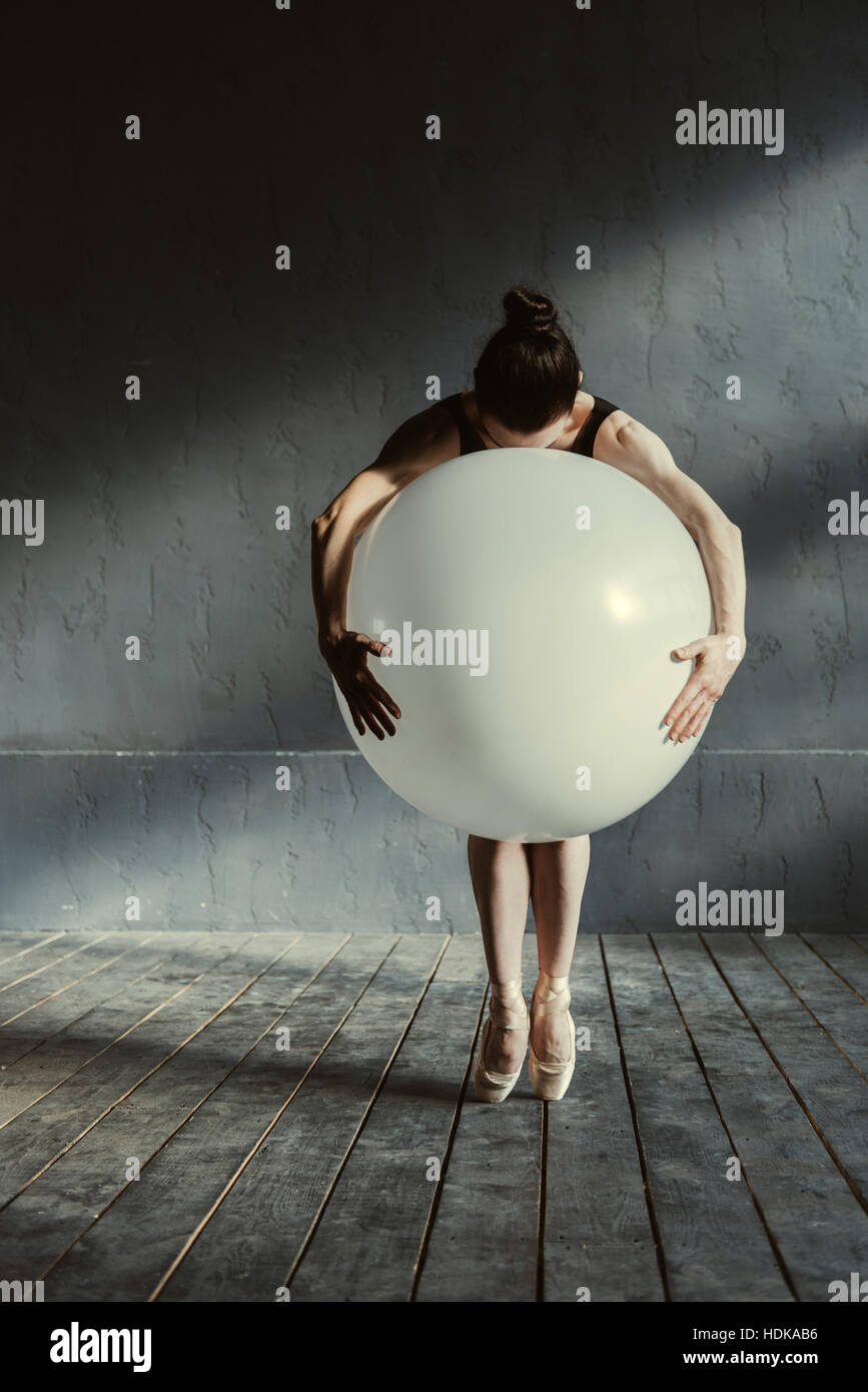 Expressive Ballett-Tänzerin mit den großen Ballon im studio Stockfoto