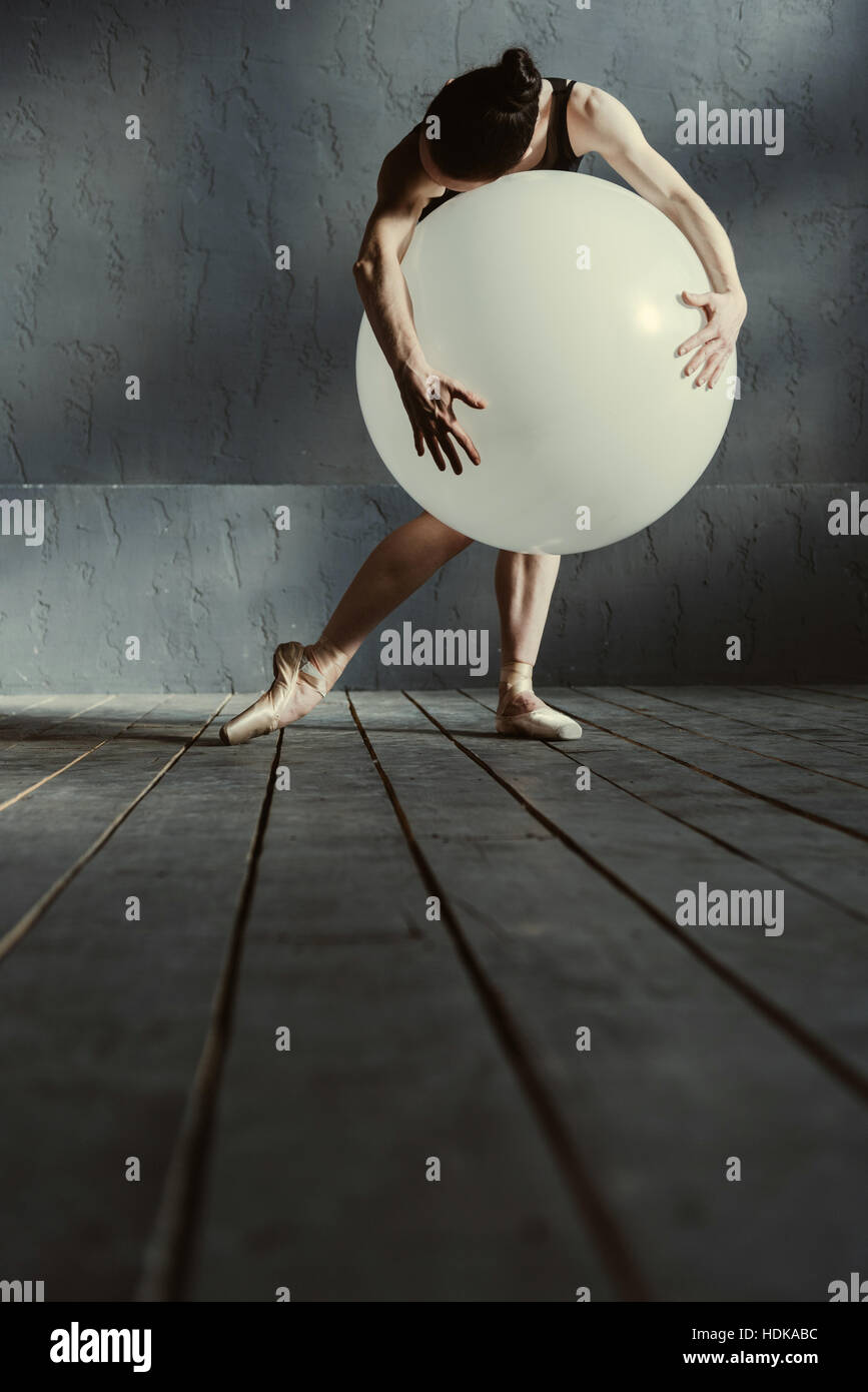 Flexible Frau tanzt mit den weißen Ballon Stockfoto