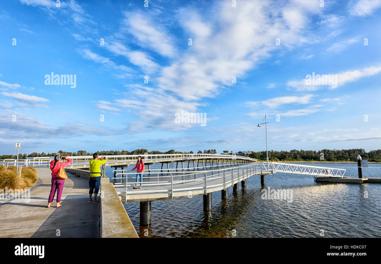 Asiatische Touristen tragen helle Farben Bilder bei Cunninghame Arm Brücke, Lakes Entrance, Victoria, VIC, Australien nehmen Stockfoto