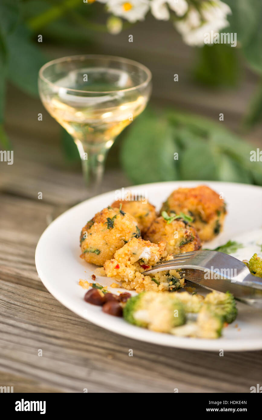 Falafel mit Brennnesseln auf einen Teller. Ein Glas Weißwein im Hintergrund. Gesunde vegetarische Kost. Stockfoto