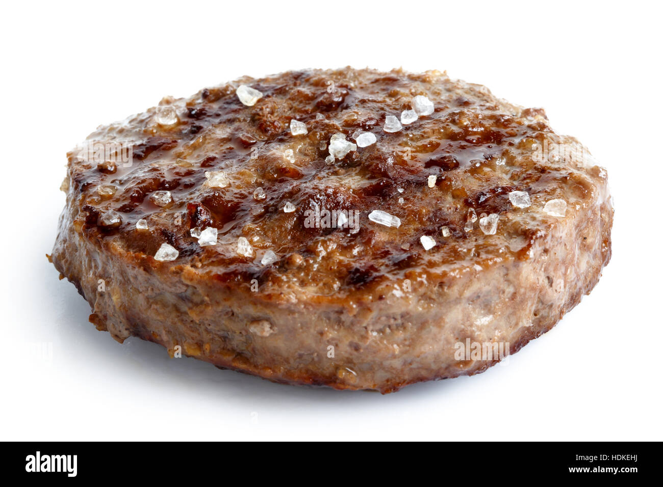 Einzelne gegrillte Hamburger Patty mit Salz isoliert auf weiss. Stockfoto