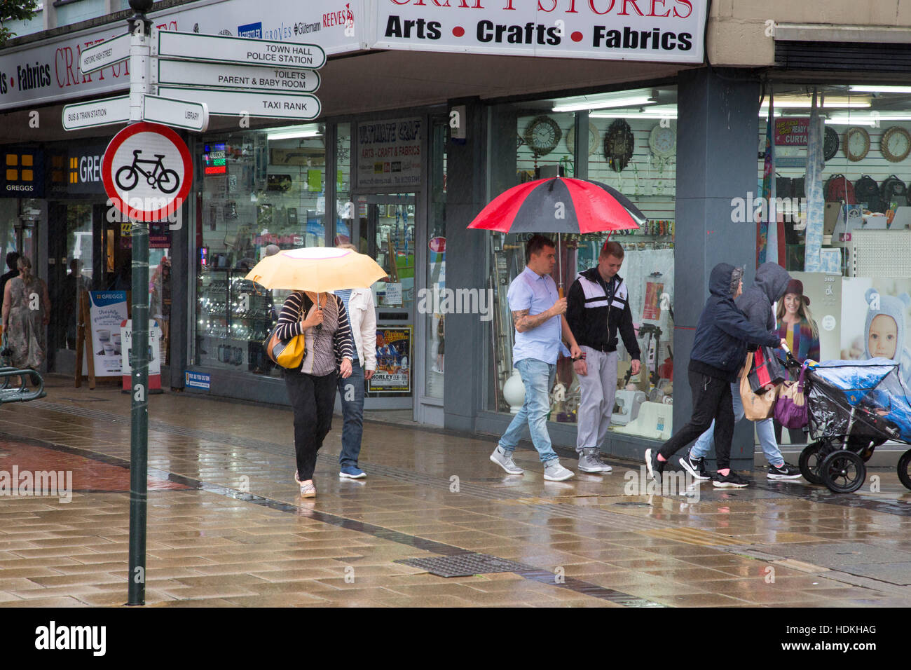 Fußgänger gehen in einer Straße bei Regenwetter. Stockfoto
