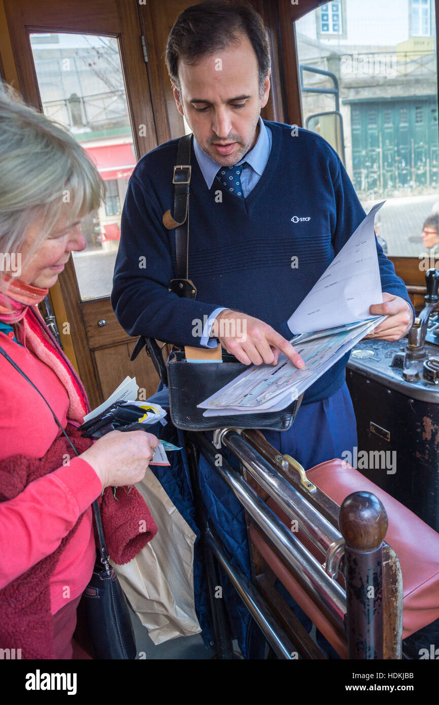 Fahrer, die Ausgabe von Tickets an eine Frau auf einem Vintage elektrische Straßenbahn, Porto (Oporto), Portugal Stockfoto