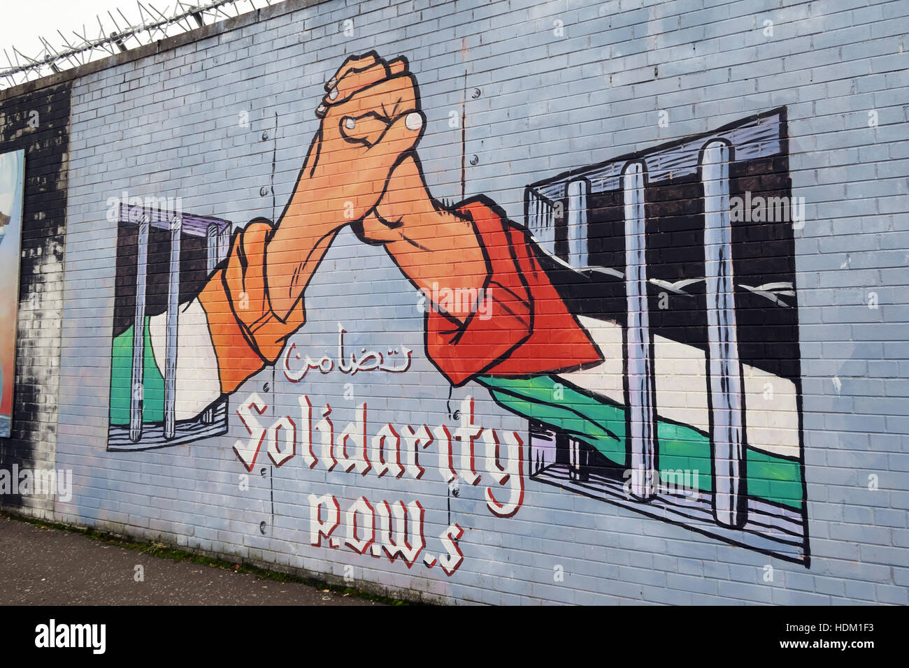 Belfast fällt Rd Rebublican Wandbild am Friedensmauer, Vereinigte Solidarität mit Kriegsgefangenen - Hände zwischen den Zellen Irland Palästina Stockfoto